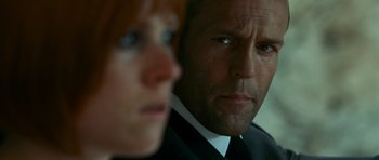 Movie still from “Transporter 3” (2008), directed by Olivier Megaton – A person wearing a suit and tie; Close Up shot, Over the shoulder angle