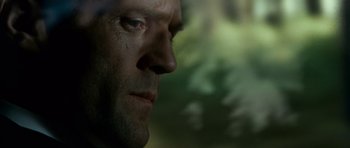 Movie still from “Transporter 3” (2008), directed by Olivier Megaton – A man's face in a forest; Close Up shot, Low angle