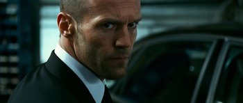 Movie still from “Transporter 3” (2008), directed by Olivier Megaton – A person wearing a suit and tie; Close Up shot, Low angle