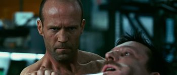 Movie still from “Transporter 3” (2008), directed by Olivier Megaton – A man with a beard is looking at another man in the mirror; Close Up shot, Over the shoulder angle