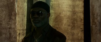 Movie still from “Transporter 3” (2008), directed by Olivier Megaton – A man wearing sunglasses and a black hat; Close Up shot, Low angle