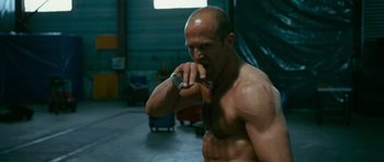 Movie still from “Transporter 3” (2008), directed by Olivier Megaton – A man brushing his teeth in a garage; Medium shot, Low angle