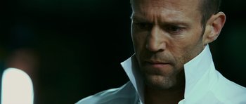 Movie still from “Transporter 3” (2008), directed by Olivier Megaton – A person wearing a white shirt; Close Up shot, Low angle