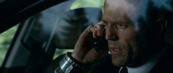 Movie still from “Transporter 3” (2008), directed by Olivier Megaton – A person talking on a cell phone; Close Up shot, Low angle
