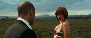 Movie still from “Transporter 3” (2008), directed by Olivier Megaton – A man and a woman standing next to each other in an open field; Medium shot, Over the shoulder angle