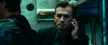 Movie still from “Transporter 3” (2008), directed by Olivier Megaton – A person on a cell phone; Close Up shot, Low angle