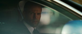 Movie still from “Transporter 3” (2008), directed by Olivier Megaton – A person wearing a suit and tie; Close Up shot, Over the shoulder angle