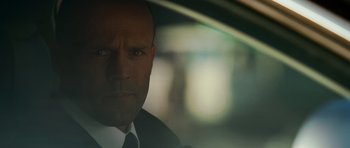 Movie still from “Transporter 3” (2008), directed by Olivier Megaton – A person wearing a suit and tie; Close Up shot, Over the shoulder angle