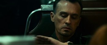 Movie still from “Transporter 3” (2008), directed by Olivier Megaton – A person sitting in a chair; Close Up shot, Low angle