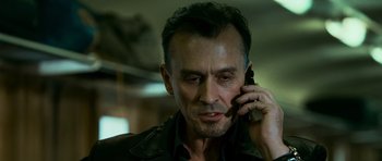 Movie still from “Transporter 3” (2008), directed by Olivier Megaton – A person talking on a cell phone; Close Up shot, Low angle