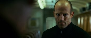 Movie still from “Transporter 3” (2008), directed by Olivier Megaton – A man with a bald head is looking at the camera; Close Up shot, Low angle
