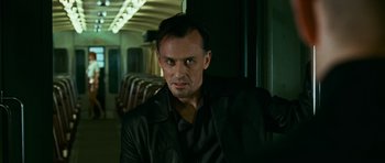 Movie still from “Transporter 3” (2008), directed by Olivier Megaton – A person sitting on a train; Close Up shot, Low angle