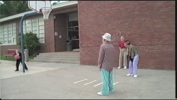 Movie still from “Trash Humpers” (2009), directed by Harmony Korine – A group of people standing in front of a brick building; Extreme Wide shot, High angle