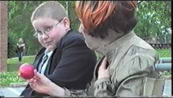 Movie still from “Trash Humpers” (2009), directed by Harmony Korine – A boy and a girl are looking at a cell phone; Medium shot, Over the shoulder angle
