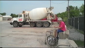 Movie still from “Trash Humpers” (2009), directed by Harmony Korine – An older man sitting in front of a cement truck; Wide shot, High angle