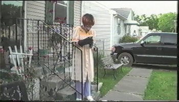 Movie still from “Trash Humpers” (2009), directed by Harmony Korine – A woman standing on the steps of a house; Wide shot, Low angle
