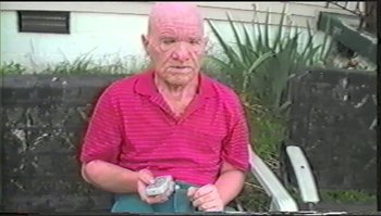 Movie still from “Trash Humpers” (2009), directed by Harmony Korine – An older man sitting outside with a cigarette in his hand; Close Up shot, High angle