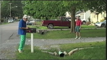Movie still from “Trash Humpers” (2009), directed by Harmony Korine – A man and a woman standing next to a tree; Extreme Wide shot, High angle