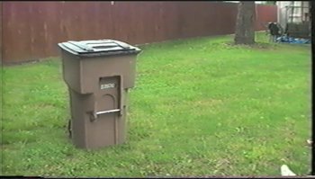 Movie still from “Trash Humpers” (2009), directed by Harmony Korine – A trash can sitting in the middle of a yard; Extreme Wide shot, Low angle