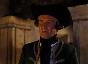 Movie still from “Treasure Island” (1950), directed by Byron Haskin – A man wearing a black hat and a green jacket; Close Up shot, Over the shoulder angle