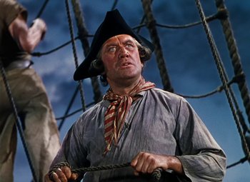 Movie still from “Treasure Island” (1950), directed by Byron Haskin – A man wearing a pirate's hat while standing on a boat; Close Up shot, Low angle