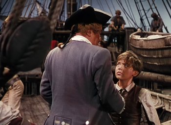 Movie still from “Treasure Island” (1950), directed by Byron Haskin – A man and a boy on a boat in the water; Medium shot, Over the shoulder angle