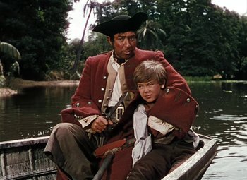 Movie still from “Treasure Island” (1950), directed by Byron Haskin – A man and a boy sitting in a boat on a river; Medium shot, High angle