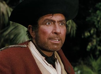 Movie still from “Treasure Island” (1950), directed by Byron Haskin – A man in a red coat wearing a black hat; Close Up shot, Low angle