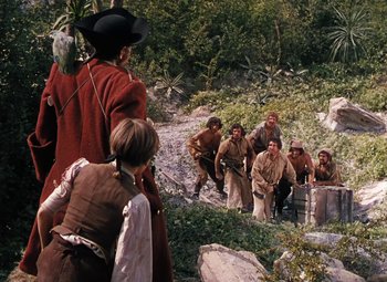Movie still from “Treasure Island” (1950), directed by Byron Haskin – A group of people standing on top of a hill; Wide shot, Over the shoulder angle