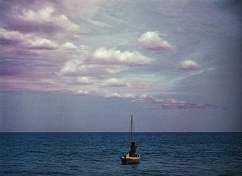 Movie still from “Treasure Island” (1950), directed by Byron Haskin – A person on a boat in the middle of the ocean under a cloudy sky; Extreme Wide shot, Low angle