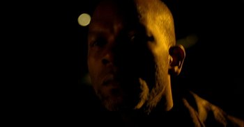 Movie still from “Trouble Every Day” (2001), directed by Claire Denis – A person's face in the dark; Extreme Close Up shot, Low angle