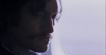 Movie still from “Trouble Every Day” (2001), directed by Claire Denis – A man's face in the dark; Close Up shot, Low angle