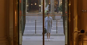 Movie still from “Trouble Every Day” (2001), directed by Claire Denis – A woman standing in front of a glass window; Wide shot, Low angle