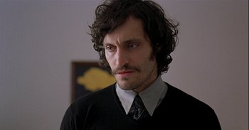 Movie still from “Trouble Every Day” (2001), directed by Claire Denis – A man with long hair wearing a tie; Close Up shot, Over the shoulder angle