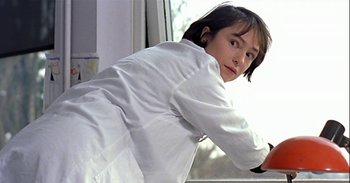Movie still from “Trouble Every Day” (2001), directed by Claire Denis – A woman in a white lab coat leaning on a window sill; Close Up shot, Low angle