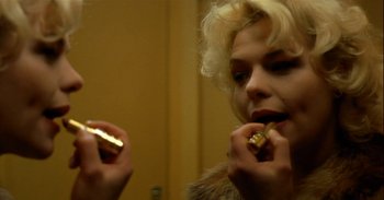 Movie still from “Trouble Every Day” (2001), directed by Claire Denis – A woman is putting lipstick in her mouth; Close Up shot, Over the shoulder angle