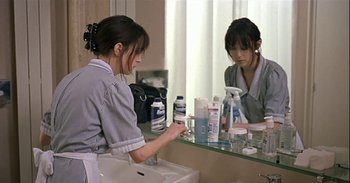 Movie still from “Trouble Every Day” (2001), directed by Claire Denis – A woman is looking in the mirror in the bathroom; Medium shot, Over the shoulder angle