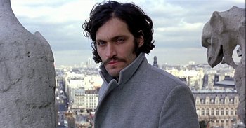 Movie still from “Trouble Every Day” (2001), directed by Claire Denis – A person wearing a coat; Close Up shot, Low angle