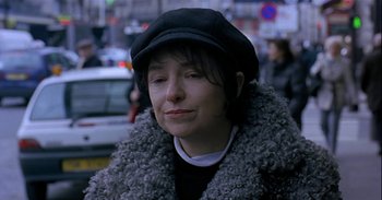 Movie still from “Trouble Every Day” (2001), directed by Claire Denis – A woman wearing a black hat and a fur coat; Close Up shot, Over the shoulder angle