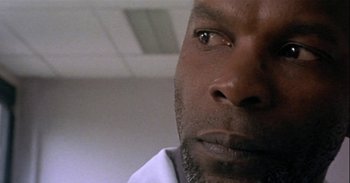 Movie still from “Trouble Every Day” (2001), directed by Claire Denis – A man's face in a white shirt; Extreme Close Up shot, Low angle