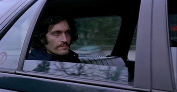 Movie still from “Trouble Every Day” (2001), directed by Claire Denis – A man sitting in the passenger seat of a car looking out of the window; Close Up shot, Over the shoulder angle