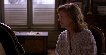 Movie still from “Trouble Every Day” (2001), directed by Claire Denis – A woman sitting in front of a window looking off to the side; Medium shot, Over the shoulder angle