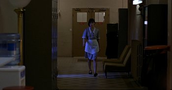 Movie still from “Trouble Every Day” (2001), directed by Claire Denis – A woman is walking down the hallway of a building; Wide shot, Low angle