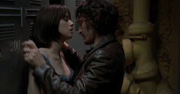 Movie still from “Trouble Every Day” (2001), directed by Claire Denis – A man and a woman are kissing in a room; Close Up shot, Over the shoulder angle
