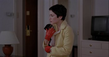 Movie still from “Trouble Every Day” (2001), directed by Claire Denis – A woman holding a small dog in her arms; Medium shot, Over the shoulder angle
