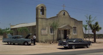 Movie still from “True Confessions” (1981), directed by Ulu Grosbard – Two men standing in front of an old church; Extreme Wide shot, Low angle