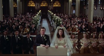 Movie still from “True Confessions” (1981), directed by Ulu Grosbard – A bride and groom standing in front of a crowd of onlookers; Wide shot, High angle