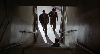 Movie still from “True Confessions” (1981), directed by Ulu Grosbard – A group of men walking down a set of stairs; Wide shot, Low angle