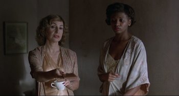 Movie still from “True Confessions” (1981), directed by Ulu Grosbard – Two women standing next to each other holding a cup; Medium shot, Over the shoulder angle