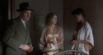 Movie still from “True Confessions” (1981), directed by Ulu Grosbard – A group of people standing next to each other in a room; Medium shot, Over the shoulder angle